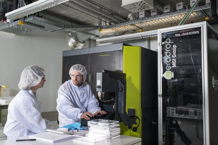 EPFL employees working with a 3D printer